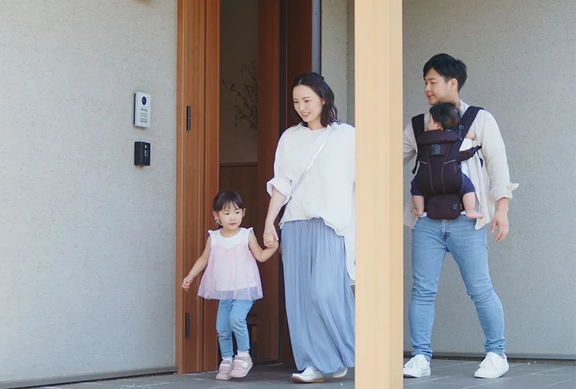 4人家族が自宅から出かける様子